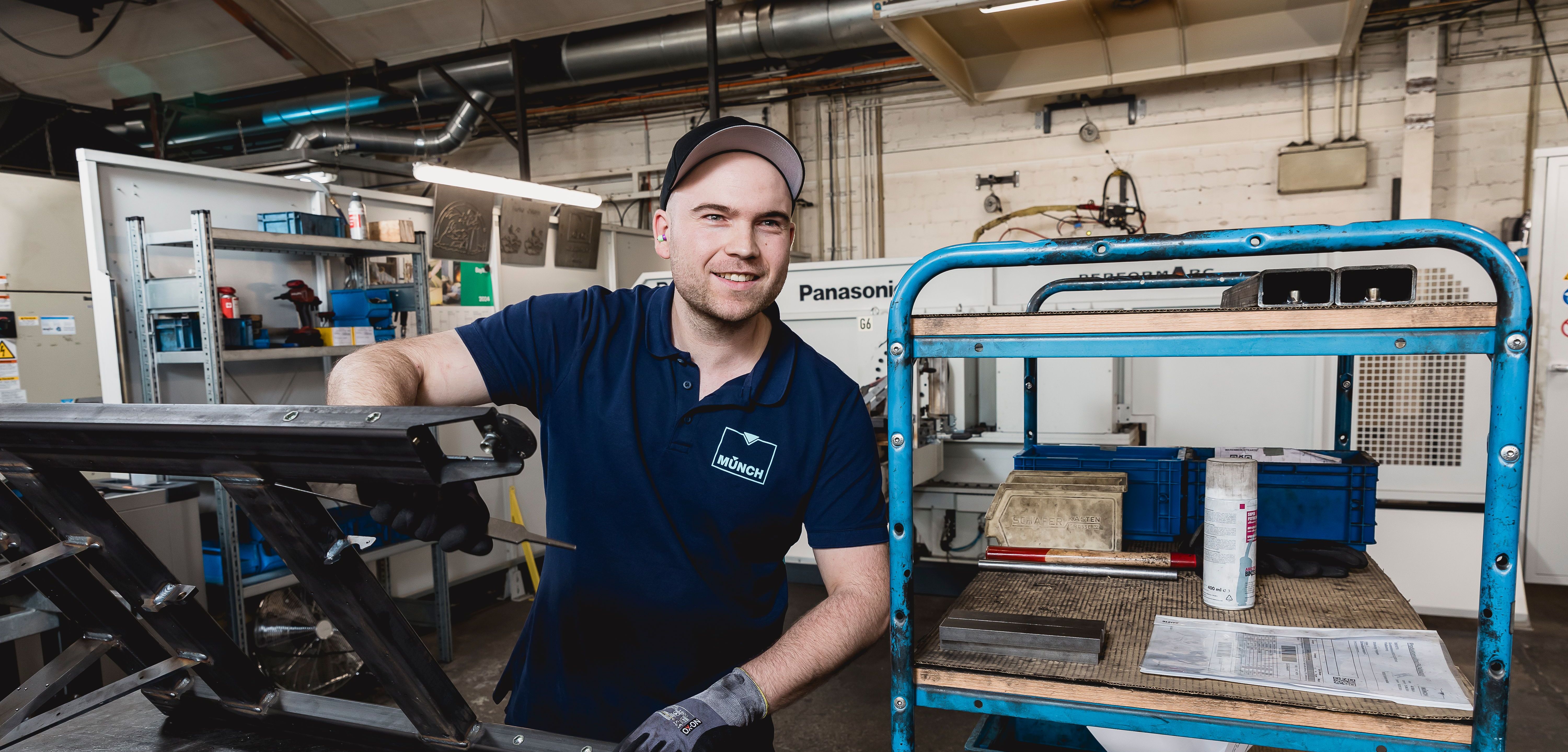 Lachender Mitarbeiter mit Bauteil