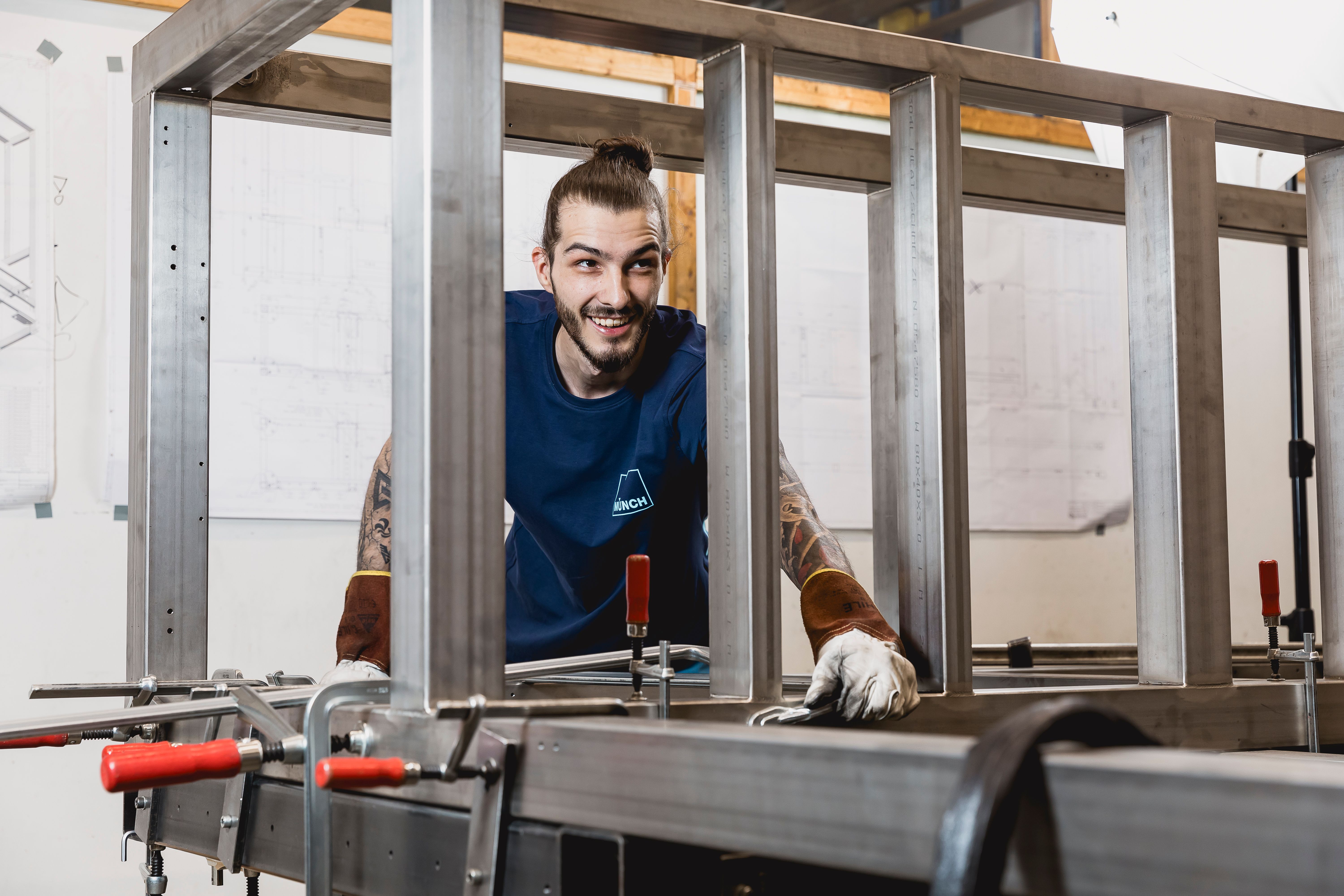 Mitarbeiter hinter Bauteil freundlich schauend