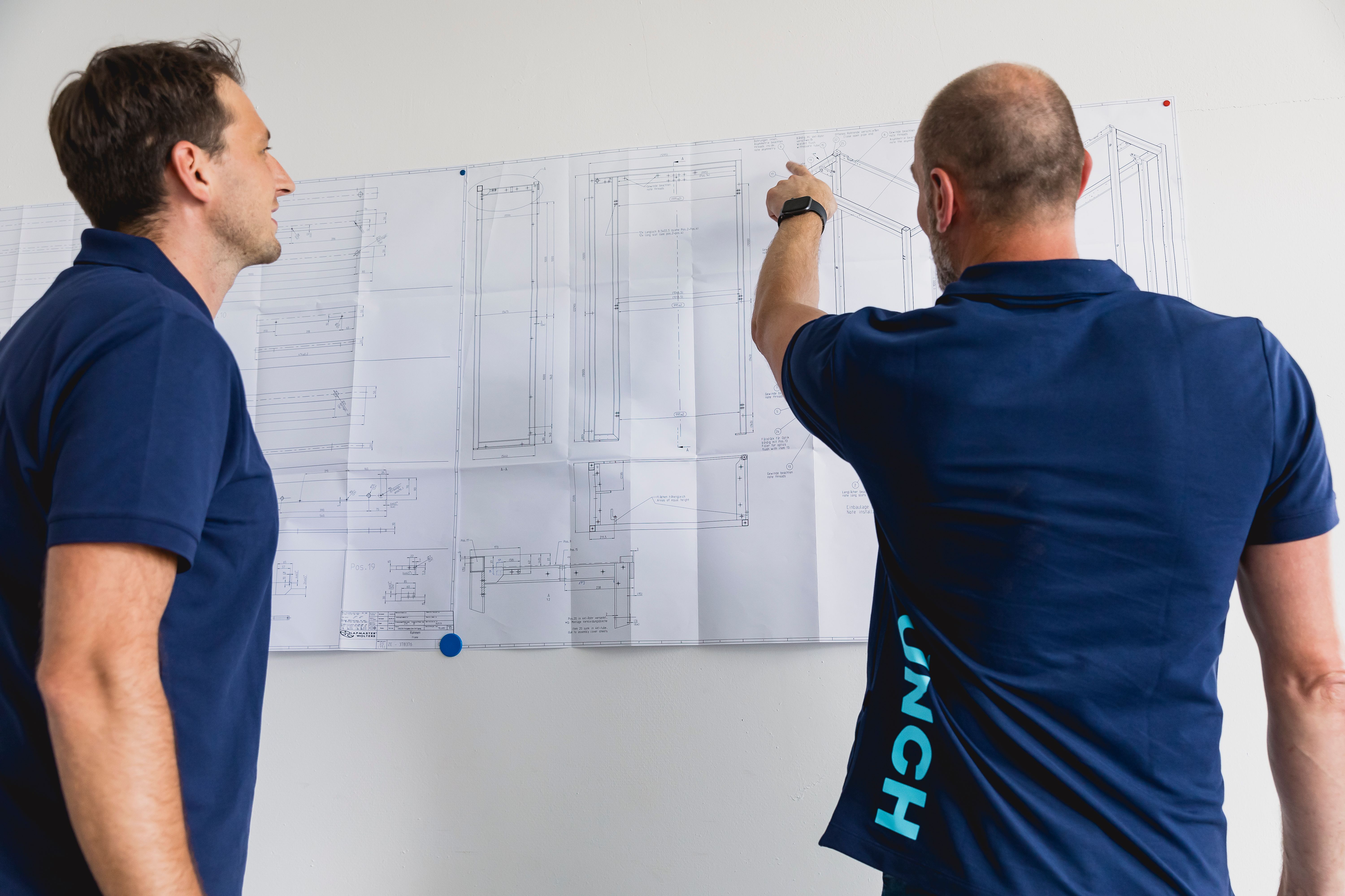 Zwei Kollegen mit technischer Zeichnung